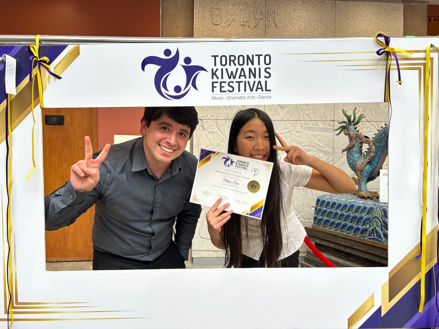 A student holding a first place certificate with Carlos Fernandez at the Toronto Kiwanis Music Festival