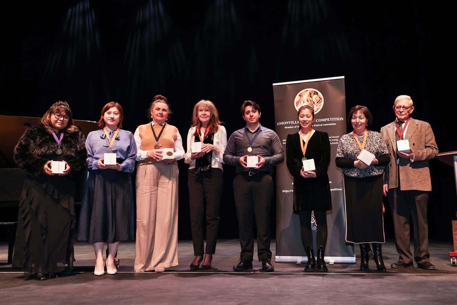 Carlos Fernandez on stage receiving a teacher award alongside other teachers at the Unionville Music Competition