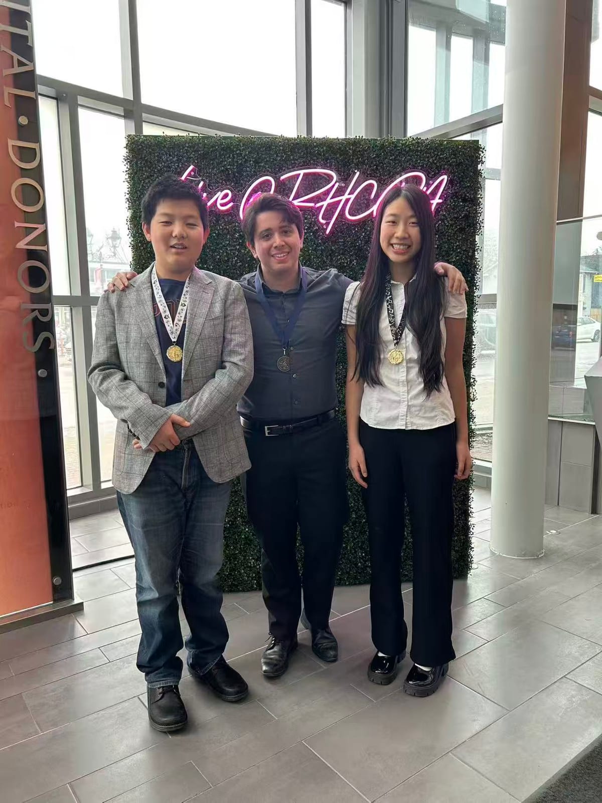Carlos Fernandez with two students wearing medals at the Unionville Music Competition